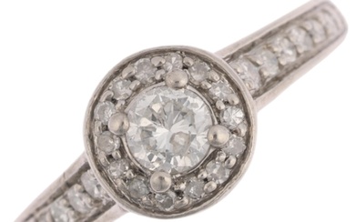 A platinum diamond halo cluster ring, set with modern round ...