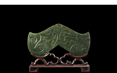 A spinach green jade "sounding stone" pendant, on wood stand (slight defects) China, 19th century (l. 16.4 cm.)