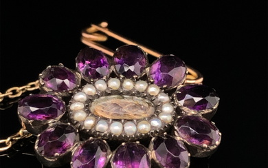 AN ANTIQUE GEMSET AND SEED PEARL MOURNING BROOCH COMPLETE WITH ATTACHED SAFETY CHAIN.