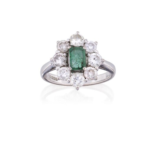 An 18ct gold, emerald and diamond cluster ring, the rectangular-cut emerald in four claw 18ct white gold mount, Sheffield hallmarks, surrounded by eight brilliant-cut diamonds, ring size P