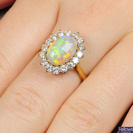 An 18ct gold oval opal cabochon and diamond cluster