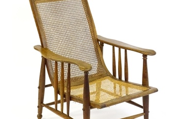 An Arts & Crafts bergère chair with a caned backrest and sea...