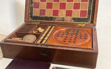 An Edwardian walnut cased games compendium featuring solitaire, chess, draaughts...