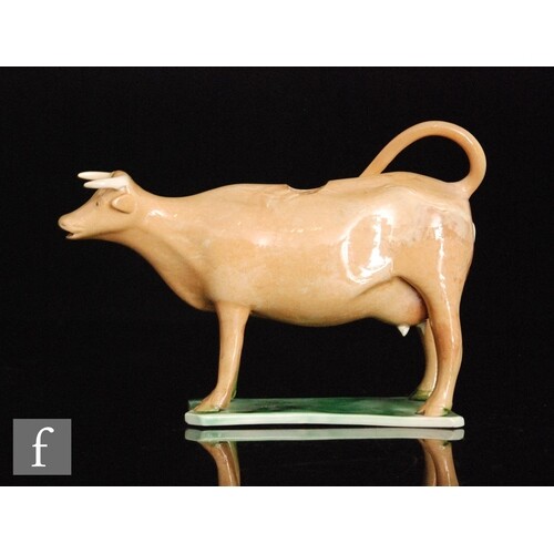 An early 19th Century Staffordshire cow creamer, cow decorat...