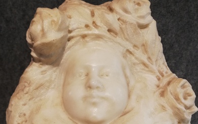 BINE, Buste en marbre blanc représentant un visage d’enfant dans un entourage de boutons de...