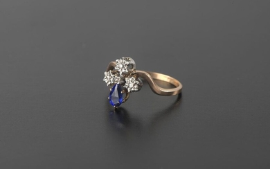 Ring in 18k yellow and white gold scratched with a pear-shaped sapphire surmounted by four small rose-cut diamonds.