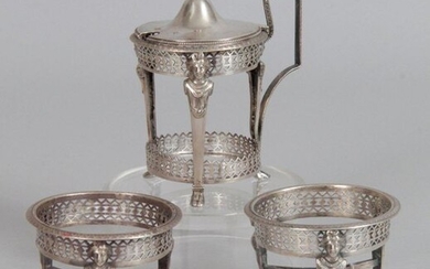 Mustard and two salerons mount in 950-thousandths openwork silver, decorated with geometric and caryatid friezes. PARIS, 1798-1809 Goldsmith: François PICARD (inscription 1784, crossed out in 1808) Weight: 240 g (One foot missing on a salt shaker...