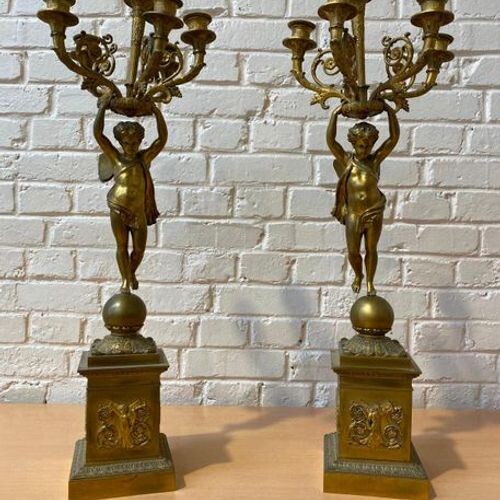 Pair of gilt bronze candelabra with putti with butterfly wings...