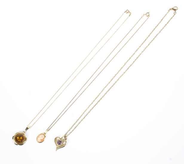 Three unmarked yellow metal gem set pendants on yellow metal chains