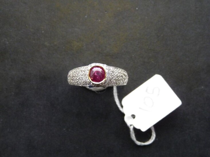 Two-tone 18K (750/oo) gold ring centered on a round ruby...