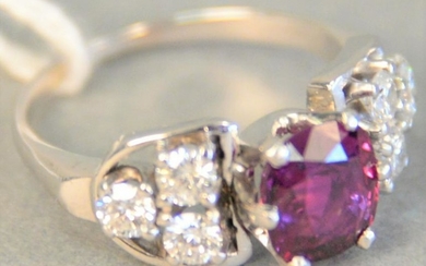 White gold ring set with center oval ruby flanked by 3