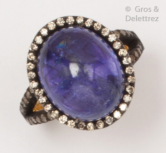 Yellow gold and blackened silver ring, adorned with a tanzanite cabochon in a setting of brilliant-cut diamonds. Finger size: 53. P. Rough: 7.4g.