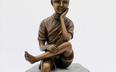 Bronze sculpture of a seated boy with cap
