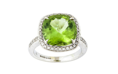 A peridot and diamond cluster ring The cushion-shaped...