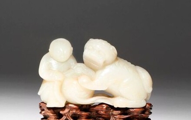 A CHINESE PALE CELADON JADE CARVING OF A BOY AND...