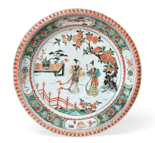 A Chinese Porcelain Charger, Kangxi, painted in famille verte enamels with figures in a fenced...