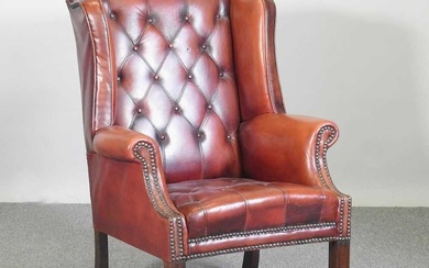 A Georgian style leather upholstered button back wing armchair, mid...