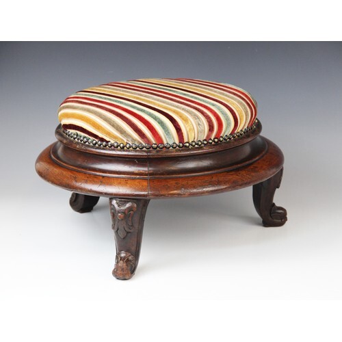 A Victorian mahogany circular foot stool, in striped fabric,...