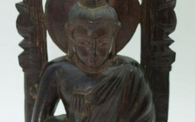 A carved hardwood South East Asian seated Buddha on a