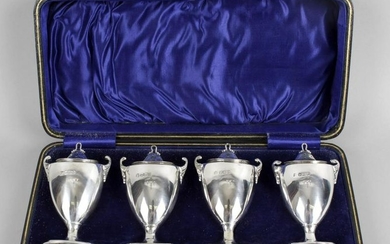 A cased set of four silver pepper pots, each of urn
