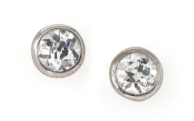 A pair of solitaire diamond ear studs each set with an old...