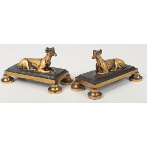 A small pair of bronze mantel figures formed as recumbent gr...
