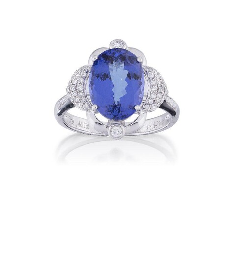 A tanzanite and diamond ring, the oval tanzanite, weighing approximately 4.93 carats, between pavé brilliant-cut diamond arched panels, with brilliant-cut diamond single stones above and below and line shoulders, hoop signed David Jerome, ring size N