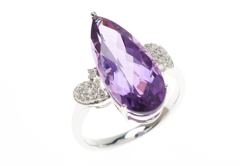 AN 18CT WHITE GOLD AMETHYST AND DIAMOND RING; centring a pear cut chequerboard amethyst of 4.91ct, between upswept shoulders set wit...