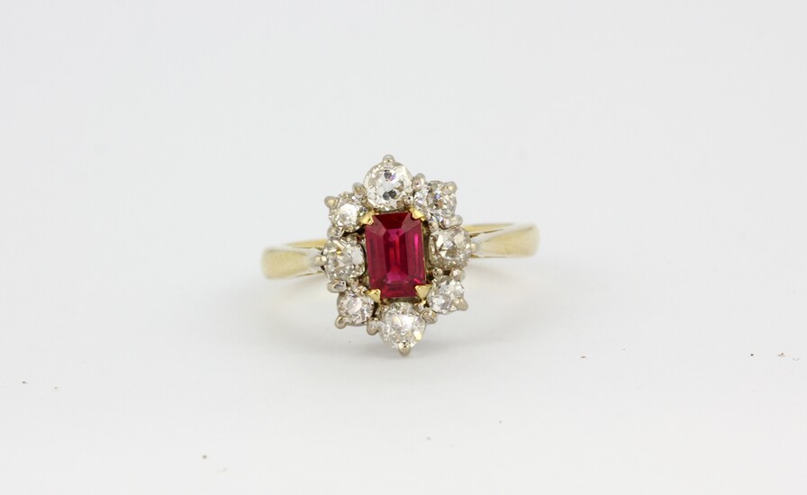 An 18ct yellow gold (stamped 18k) cluster ring set with an emerald cut ruby surrounded by old cut diamonds, M.5).