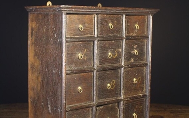 An 18th Century Oak Cabinet of Drawers, set in four rows of three; each with a small brass ring hand