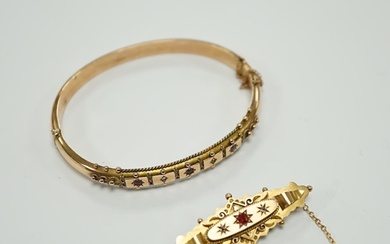 An Edwardian 9ct gold ruby and diamond chip set hinged bangl...
