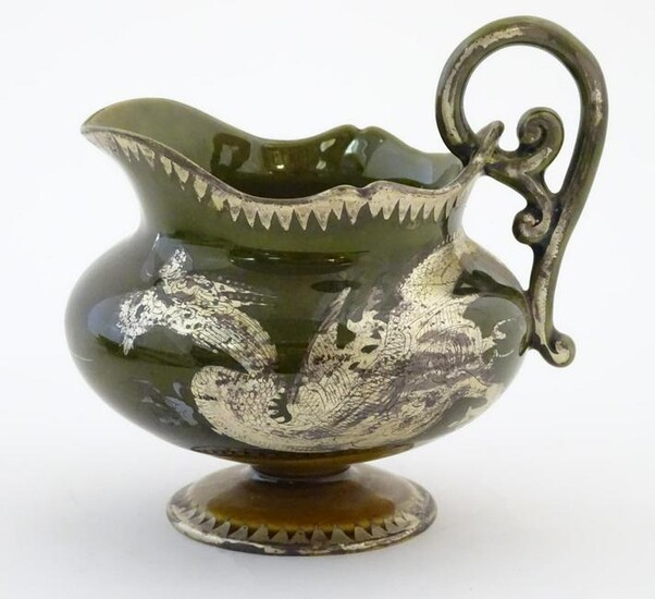 An Oriental pedestal cream jug with gilt dragon detail.