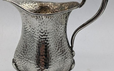 An early 20th century Arts and Crafts silver jug