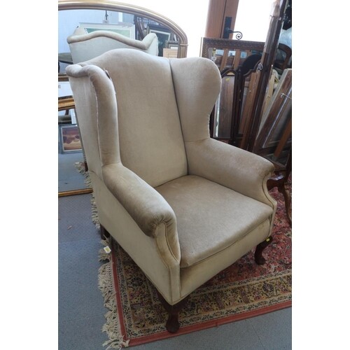 An early 20th century wing armchair, upholstered in a gold v...