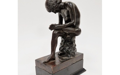 Bronze figure of a seated young nude male , looking at the s...