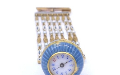 CHATELAINE in 18K yellow gold (9K pin) held by seven chains made of white pearls (untested) and blue and white enamel. (enamel shock). Length: 10 cm. Gross weight : 26.31 gr. An enamel, pearl and gold watch.