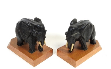 Deux serre-livres en bois sculpté formant des éléphants sur un socle en bois, signé PEHEM....