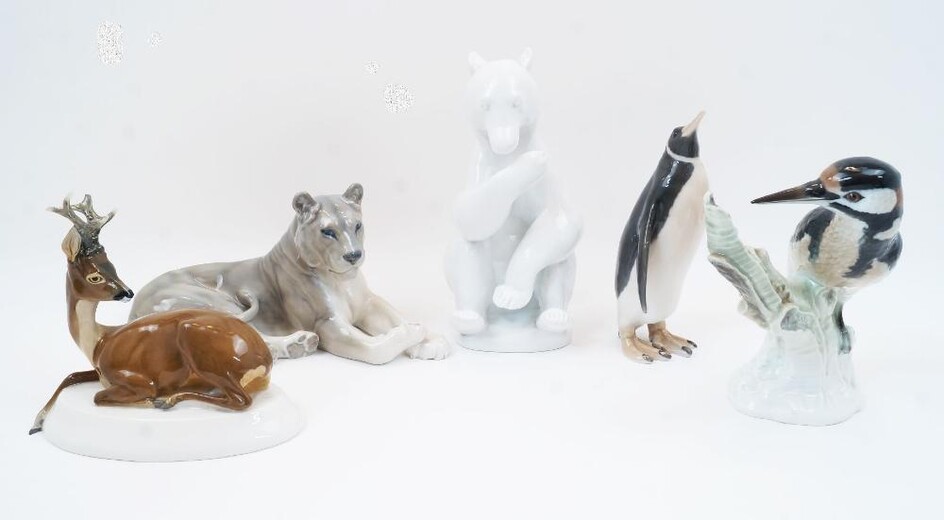 Five Continental porcelain models of animals and birds, comprising: a Berlin KPM porcelain woodpecker perching on a tree stump, first half 19th century, blue scepter and blue orb marks to the underside, 22cm high; a Meissen seated stag with turned...