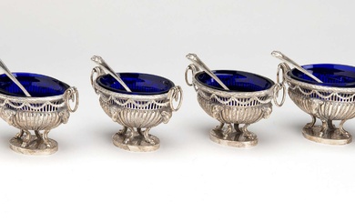 Four English silver salts with blue glass liners and four spoons.