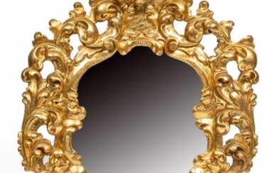 Important miroir mouvementé en bois sculpté et doré à riche décor ajouré de feuillages, palme...