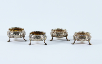 Lotto composto da quattro diverse saliere in argento sbalzato a motivo floreale, di forma circolare su tre piedi. Londra, secolo…