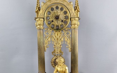 Pendule portique en bronze patine dorée, de style gothique, représentant une femme assise tenant une...