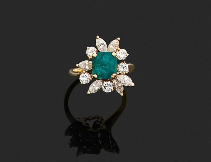RING in 750 thousandths yellow gold, decorated with a rectangular cut-faceted emerald, in a setting of eleven round brilliant cut diamonds and shuttle. Finger size: 50.5. Gross weight: 5.1 g. Presumed weight of the emerald about 1.80 to 2.10 ct...