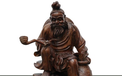 Scultura in legno intagliato di un uomo con la pipa