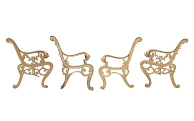 Two similar pairs of gold painted cast metal bench ends, each with a lion mask motif.