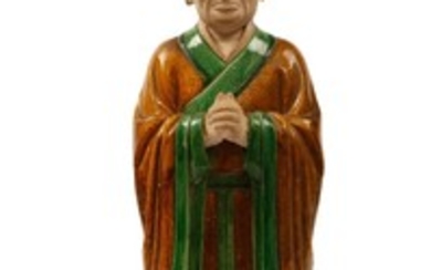 A CHINESE SANCAI-GLAZED MODEL OF A LOHAN. Ming...