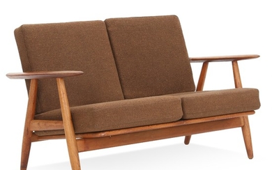 Hans J. Wegner: “The Cigar”. Two seater sofa with patinated oak frame. Cushions in seat and back upholstered with brown wool. L. 122 cm.