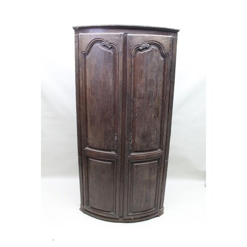 A 19TH CENTURY OAK BOW FRONT TWO DOOR CUPBOARD with part fit...