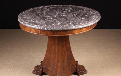 A 19th Century Mahogany Gueridon. The round grey mottled marble top with a moulded border,standing o
