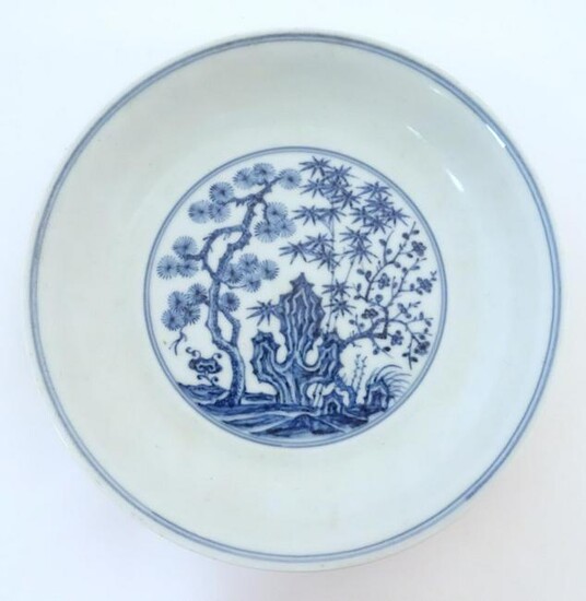 A Chinese blue and white dish with blossoming trees and